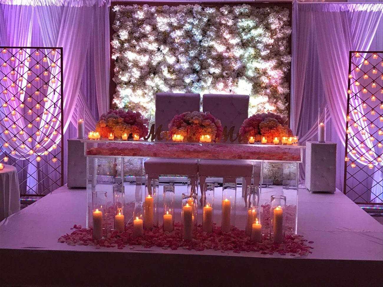 Wedding head table with floral wall and candles