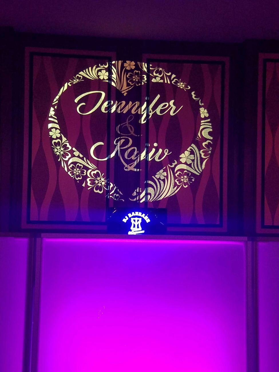 Illuminated monogram behind the DJ booth