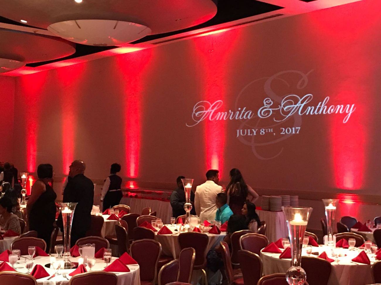Reception room in red uplighting with a projected monogram